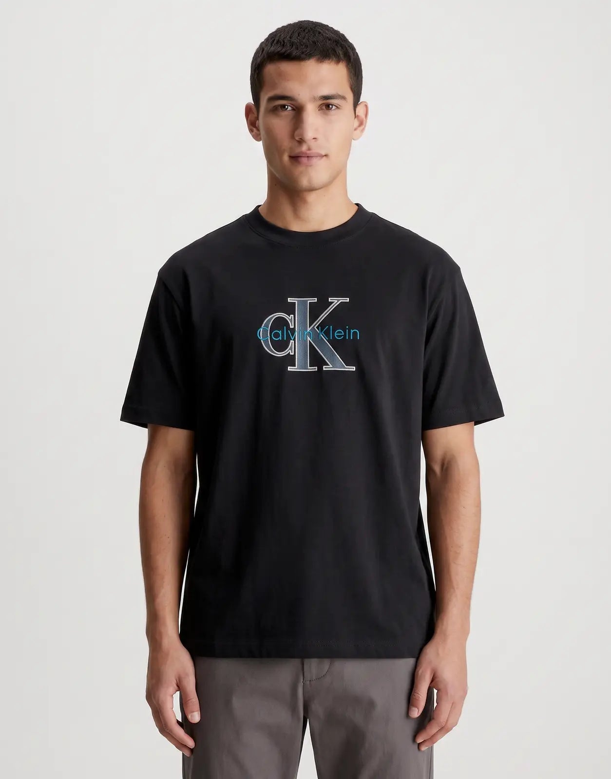 Calvin Klein 16s Tricolor Monologo Graphic Black T-Shirt. A comfortable short-sleeve tee featuring a distinctive blue and