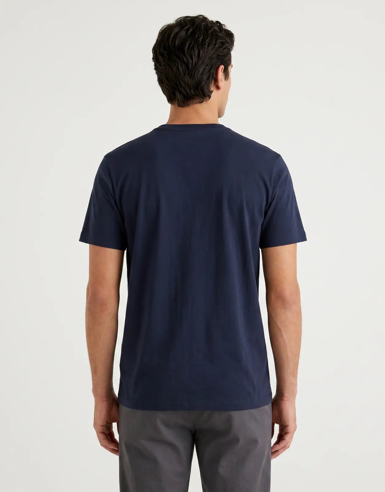 Back view of a plain navy Calvin Klein 30s Wholesale Jeans graphic t-shirt, made from soft fabric, neatly laid flat on a