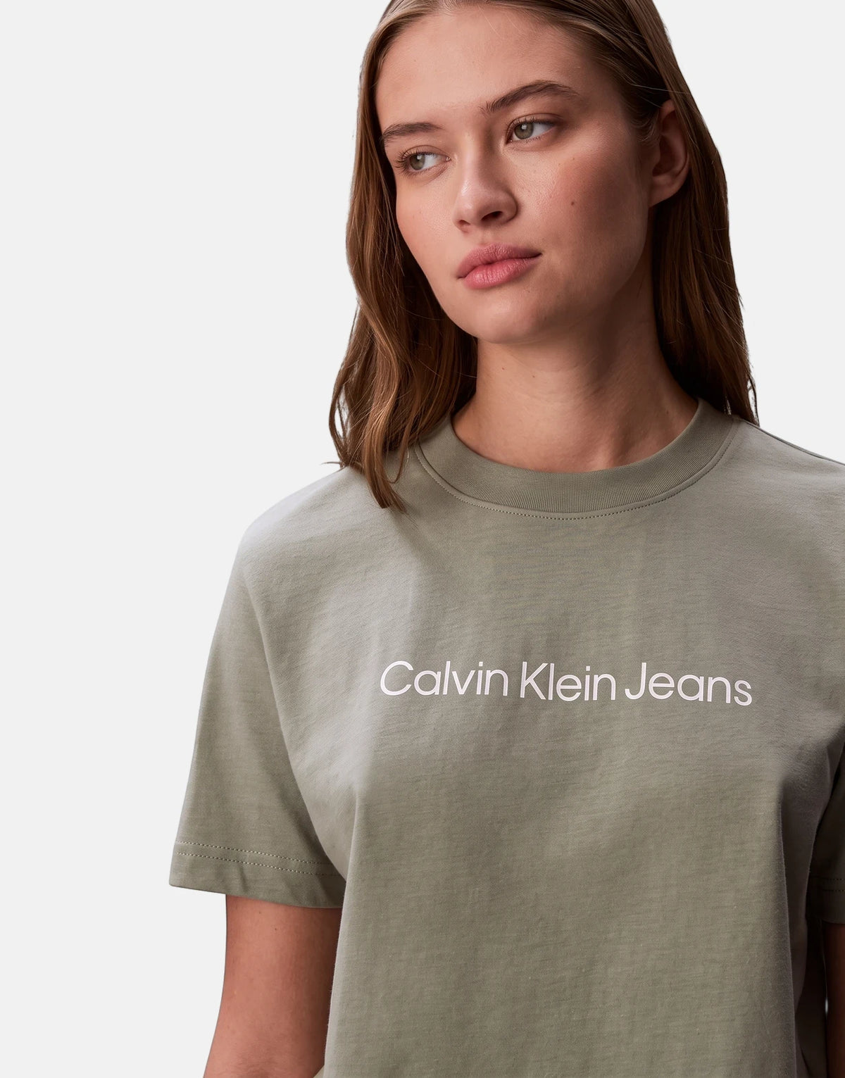 Woman wearing a Calvin Klein A-Inst Logo Classic T-Shirt in olive green, featuring a white brand logo on the chest, studio