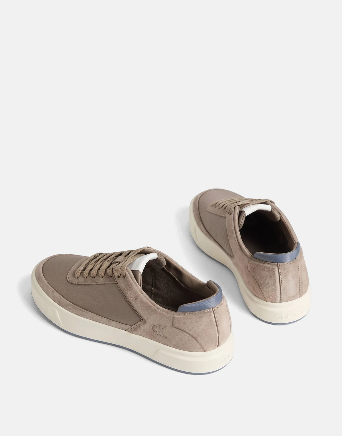 Two taupe Calvin Klein Basket Cupsole Laceup Multi Sneakers, featuring white midsoles and blue accents, floating against a