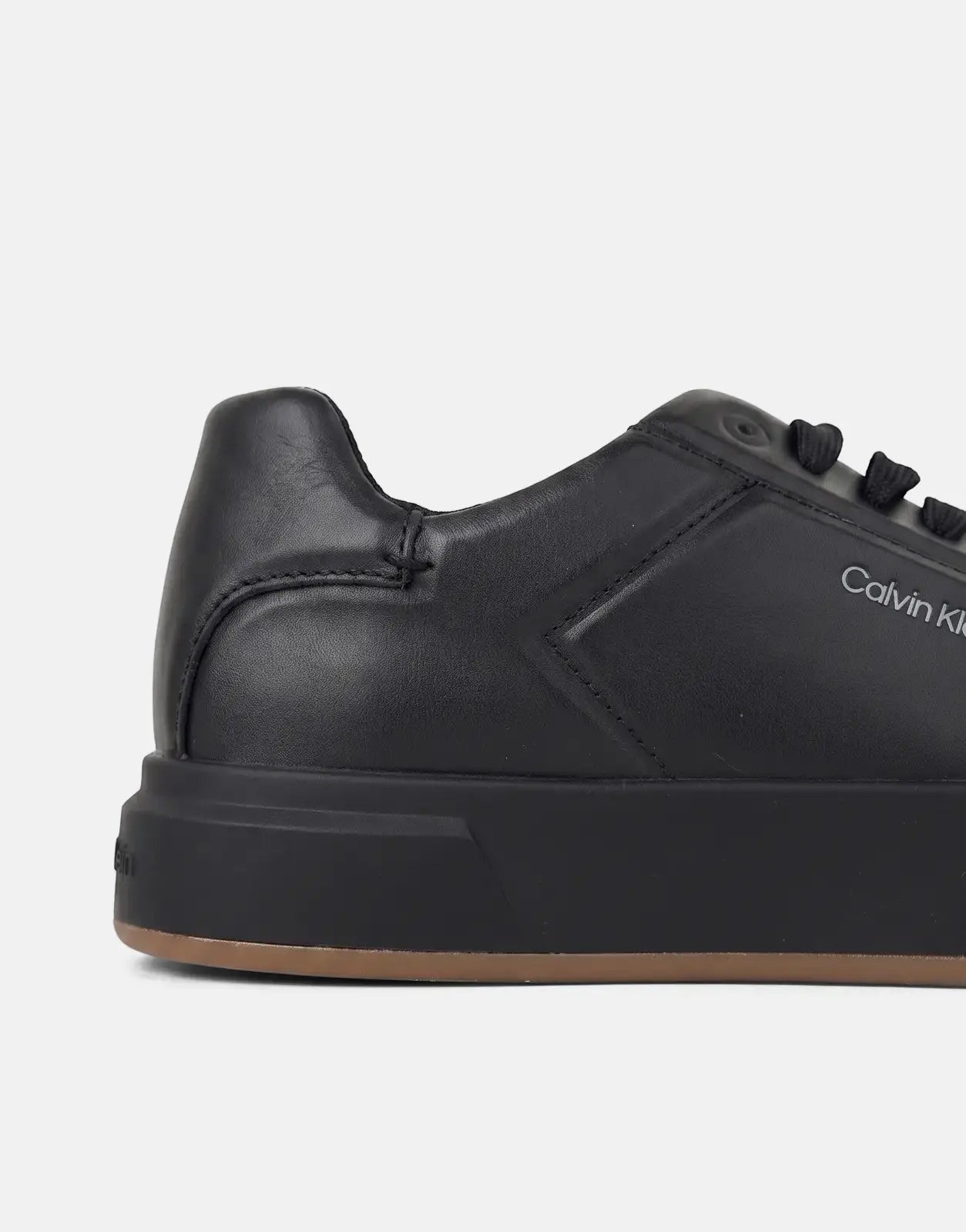 Close-up of a black Calvin Klein Basket Cupsole Oxford Laceup sneaker, showcasing its leather texture and brand logo.