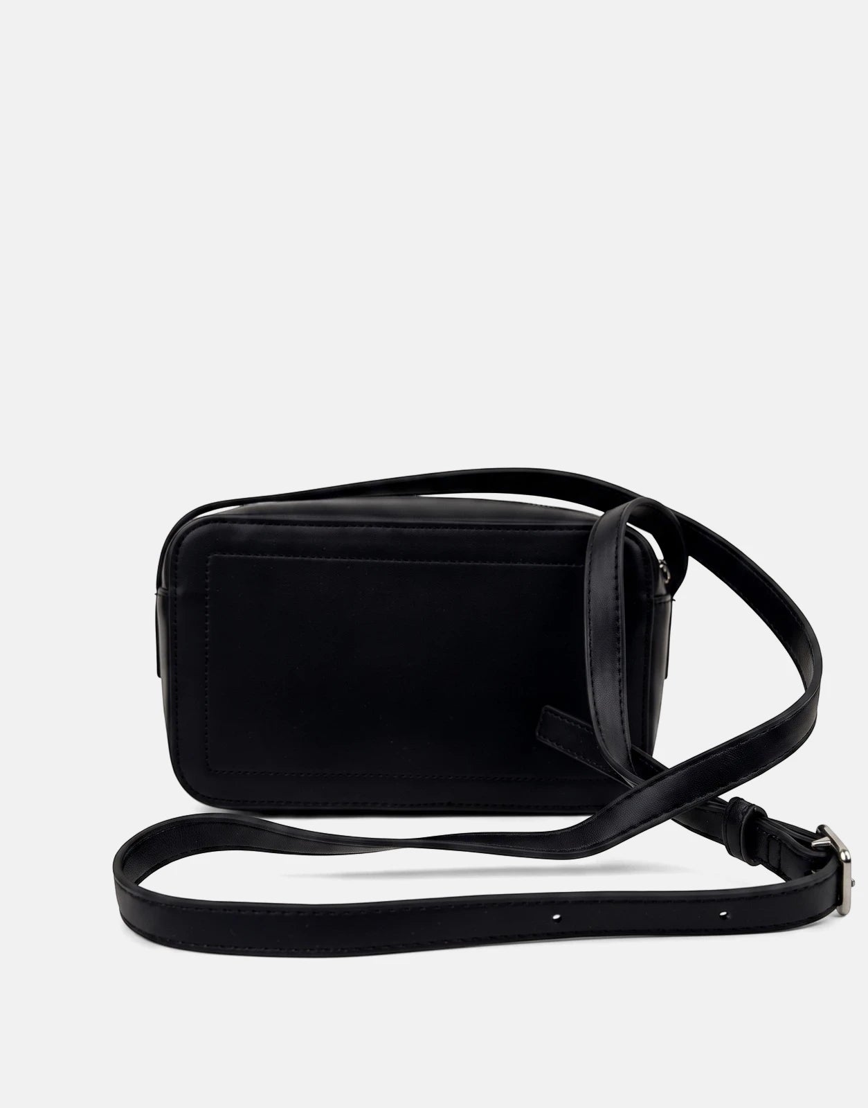 A black Calvin Klein Bold CK camera bag, made of smooth material, displayed from a side-rear view with its adjustable strap