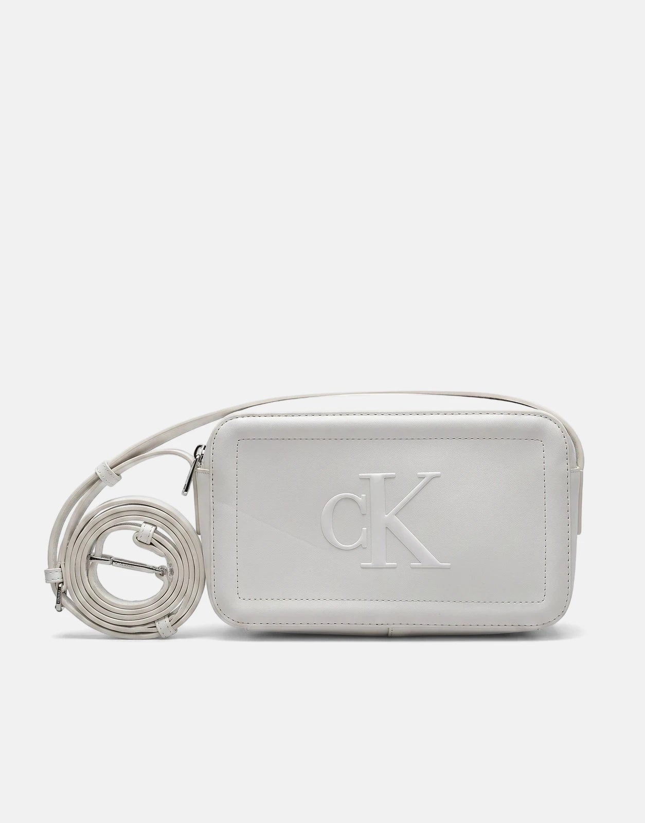 A white Calvin Klein Bold CK camera bag with an embossed logo and an adjustable strap, displayed from the front.