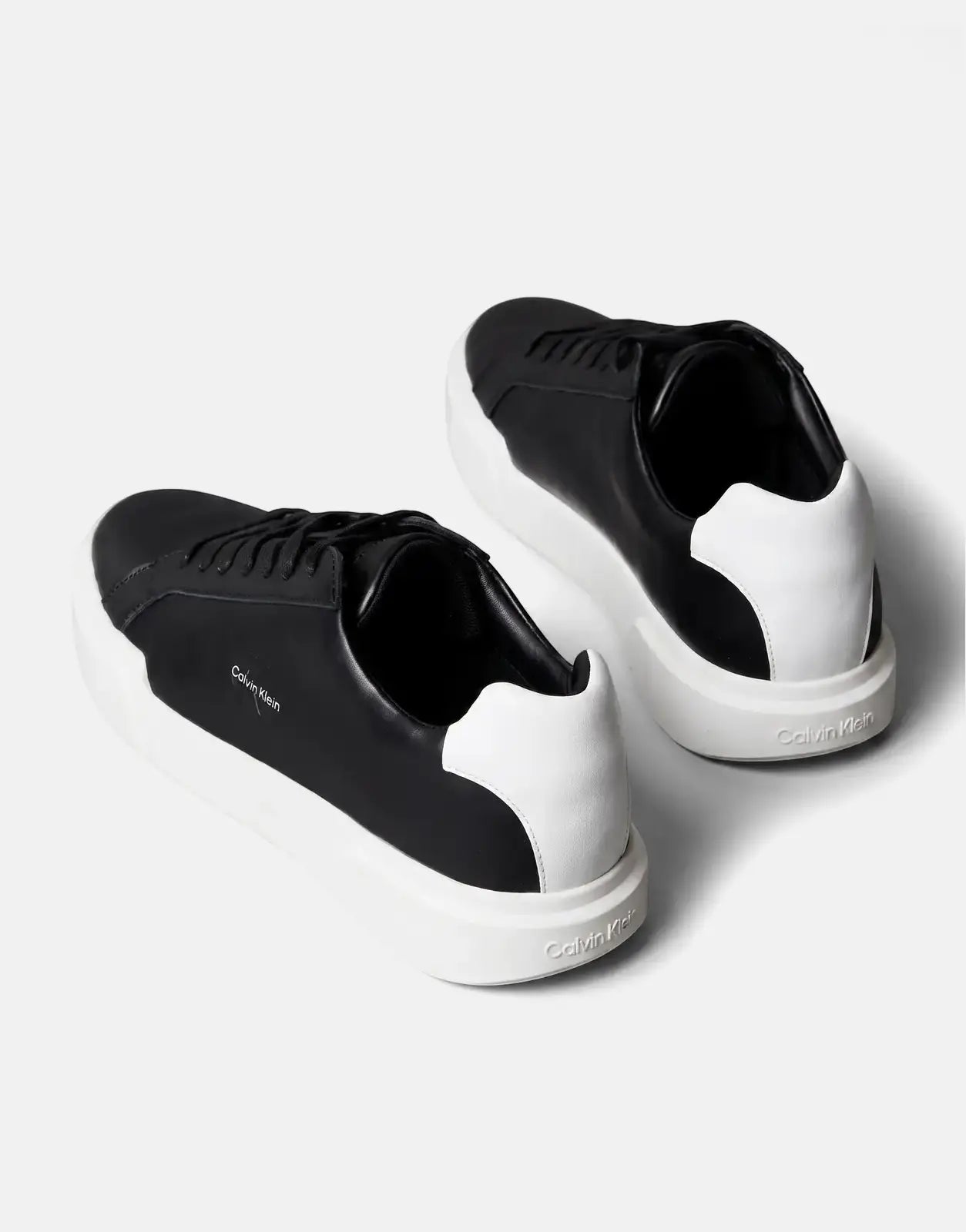 Pair of Calvin Klein Chunky Cupsole Sneakers in black and white leather, shown from a rear-quarter view.