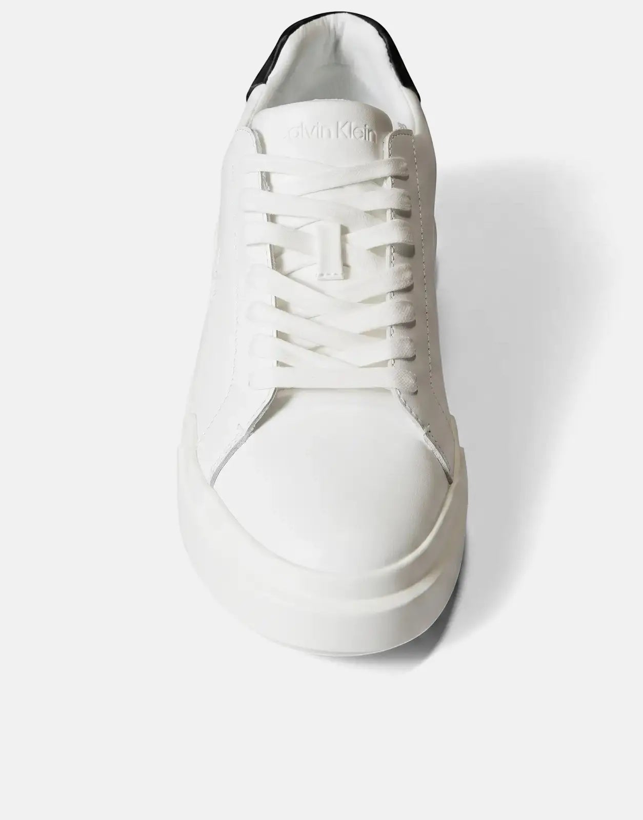 Front view of a white Calvin Klein Chunky Cupsole Sneaker with a black ankle cuff and white laces, featuring a thick sole.