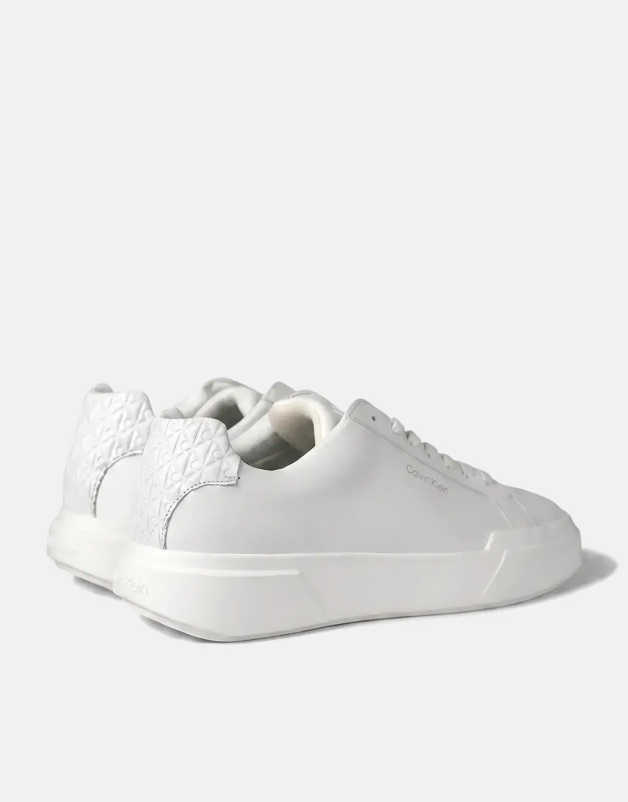 Calvin Klein Chunky Cupsole white leather sneakers with textured heel detail, viewed from a rear-quarter angle on a white