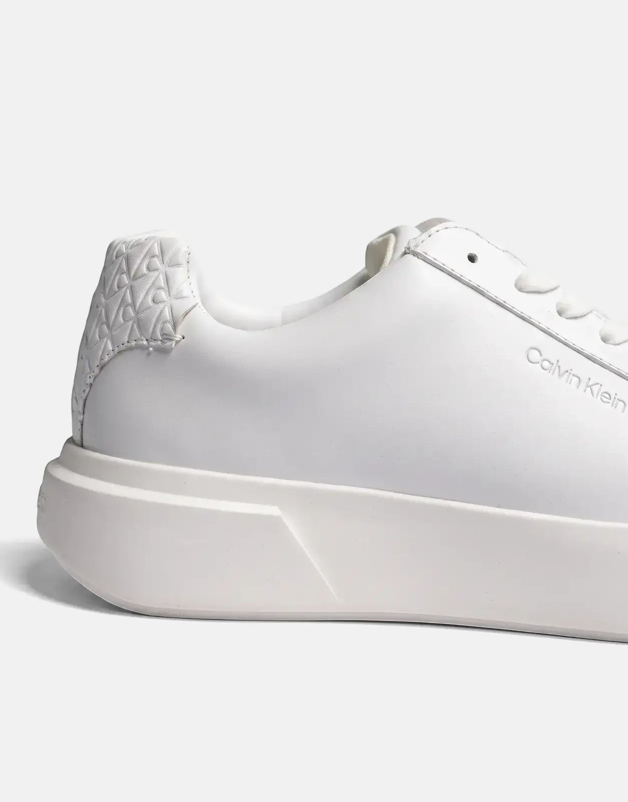 Side view of Calvin Klein Chunky Cupsole White Sneakers, showcasing a sleek white upper, chunky sole, and embossed heel
