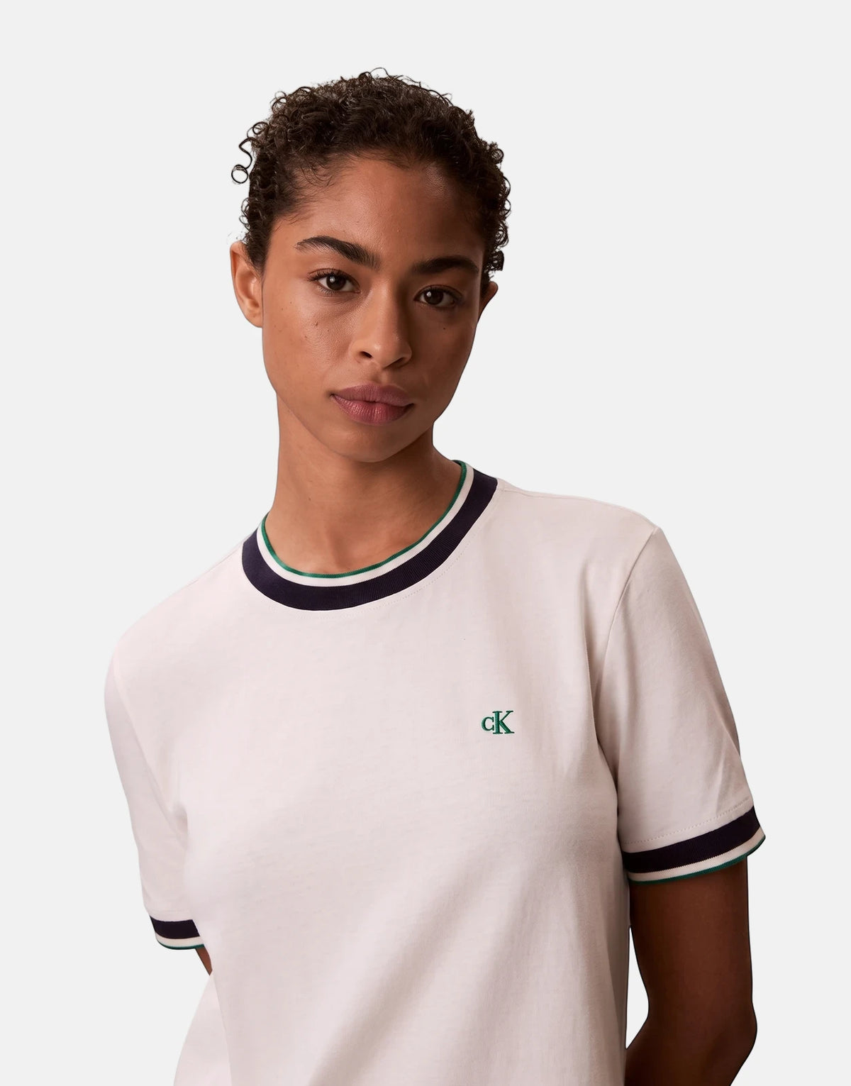 Woman wearing an off-white Calvin Klein CTN Monogram Stripe Trim Mini Dress with navy and green accents. Close-up view.