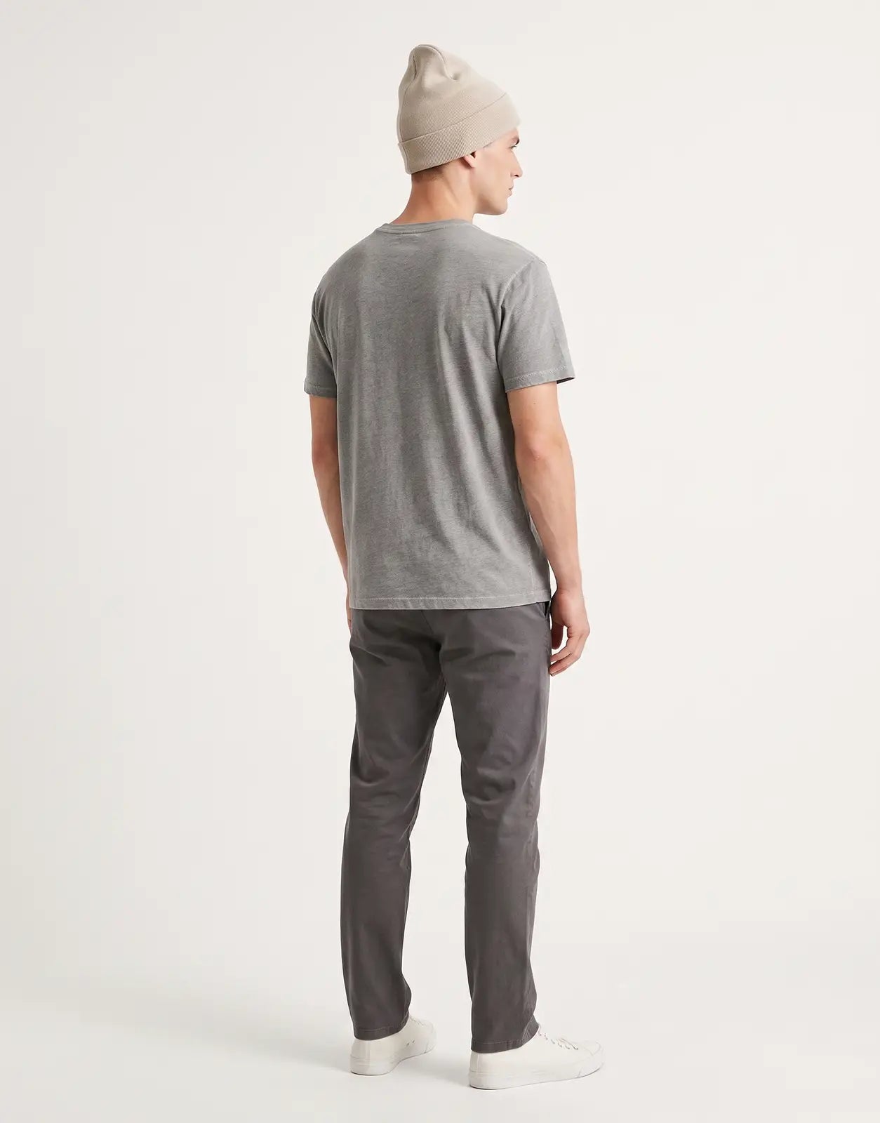 Back view of a Calvin Klein fine rib knit beanie in a light beige color, featuring a soft texture and a folded cuff design.