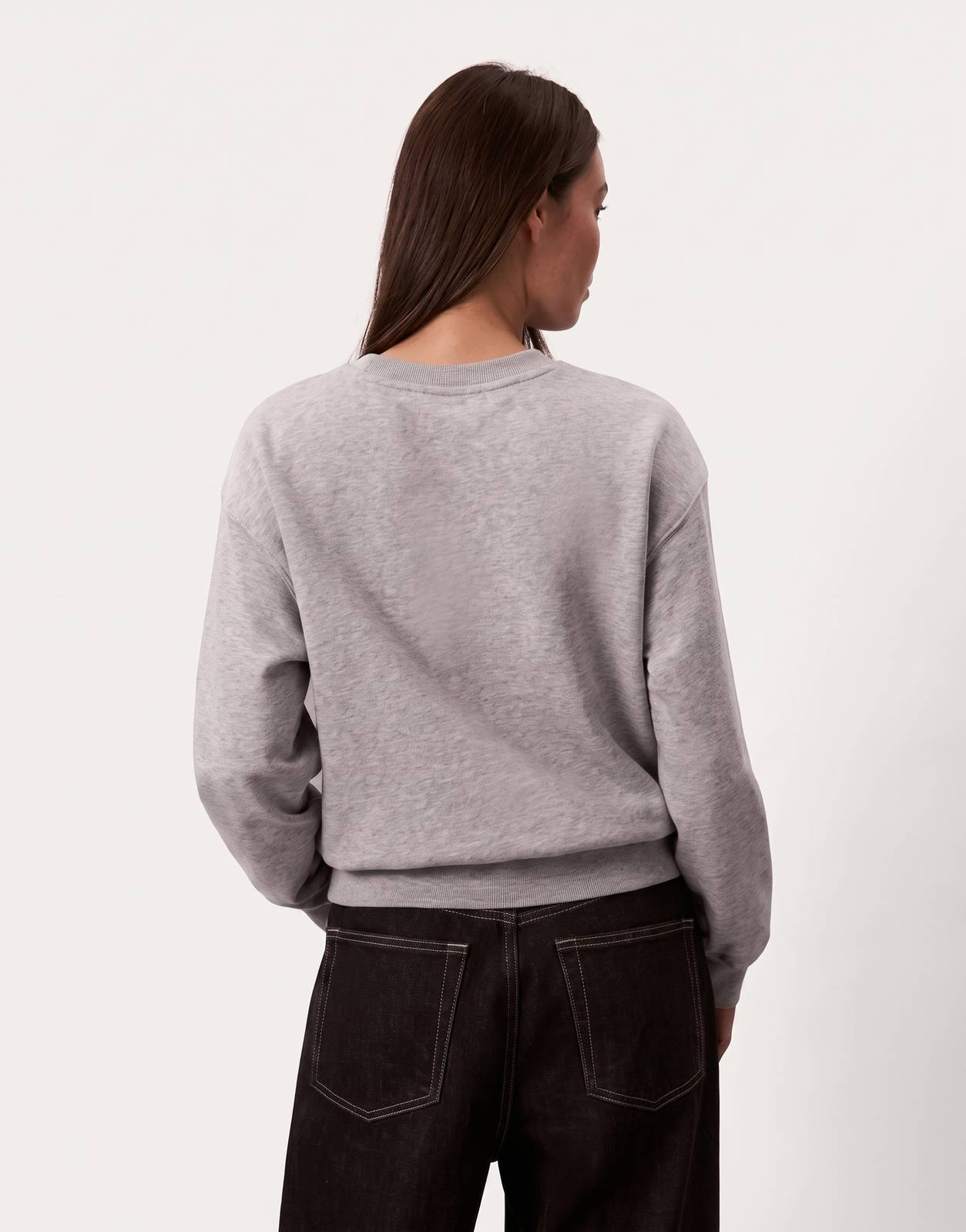 A model from the back wearing a Calvin Klein Foil Monologo French Terry Relaxed Grey Sweatshirt paired with dark jeans.