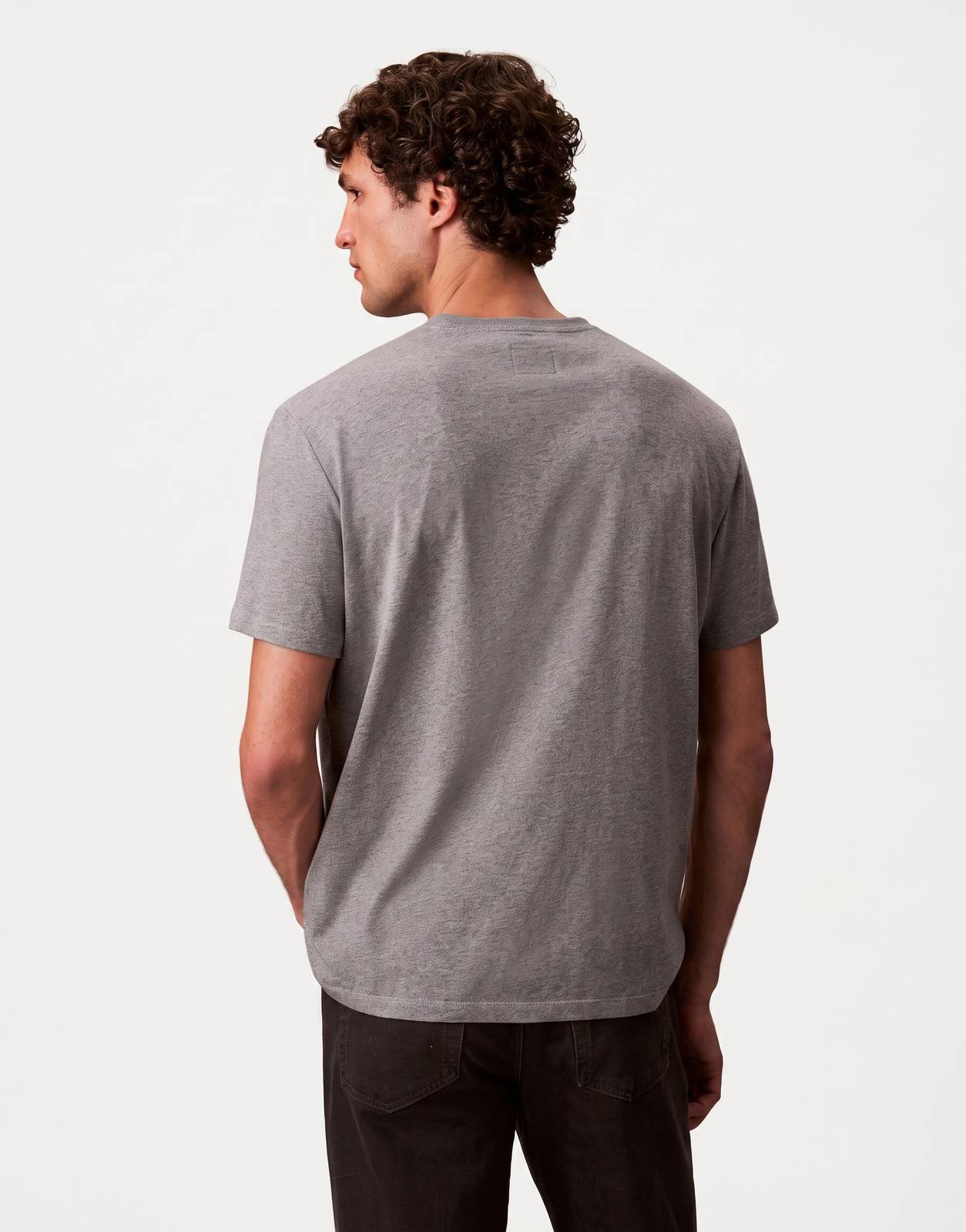 A male model from behind wearing a plain grey Calvin Klein Hero Monologo T-shirt with short sleeves.
