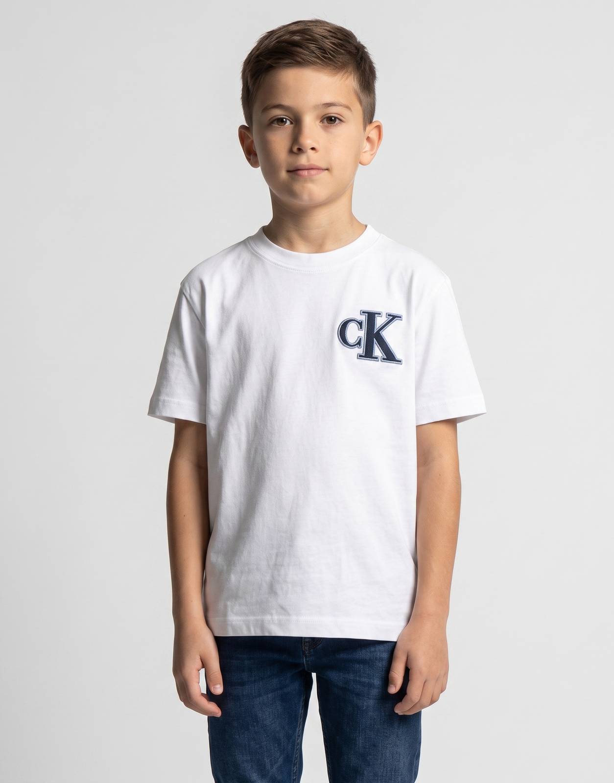 White Calvin Klein Kids Festive T-Shirt with navy CK logo on chest, short-sleeve, crew-neck, worn by a child.