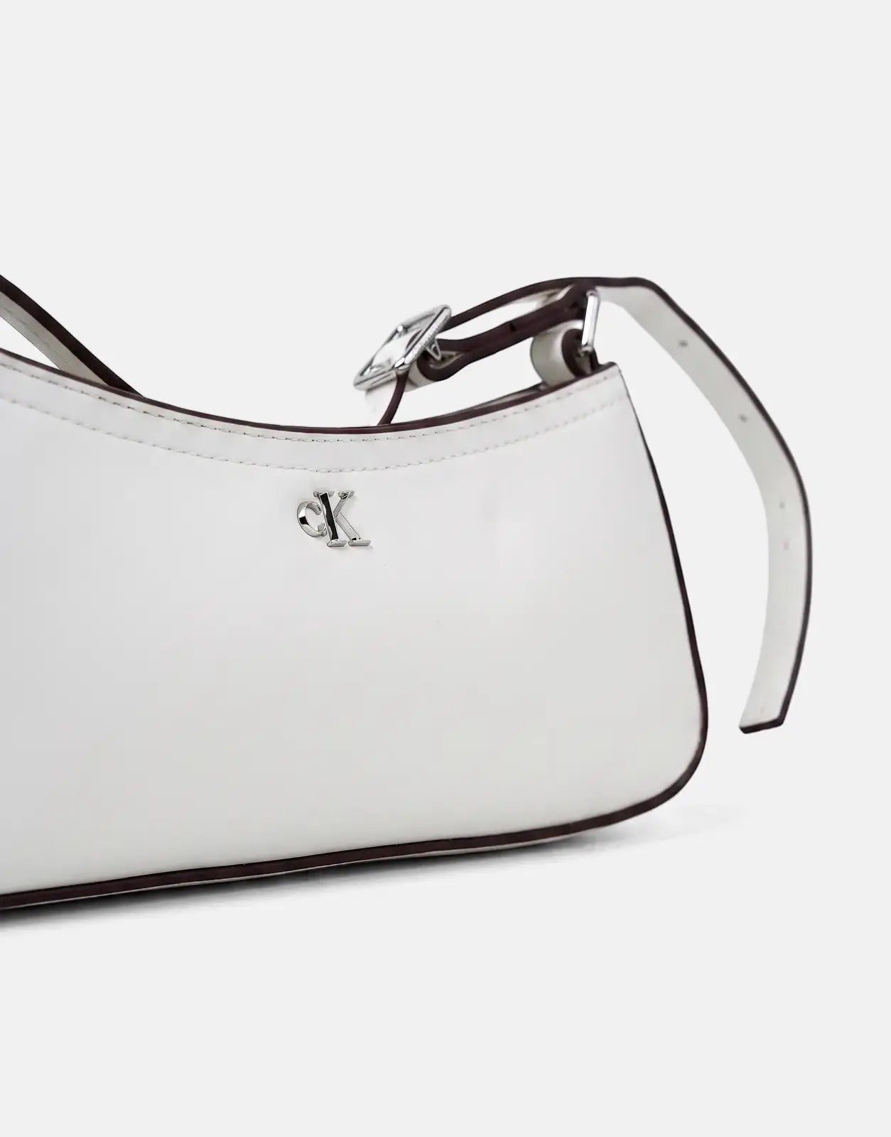 Calvin Klein small white leather shoulder bag with silver-tone 'CK' logo and adjustable buckle detail.