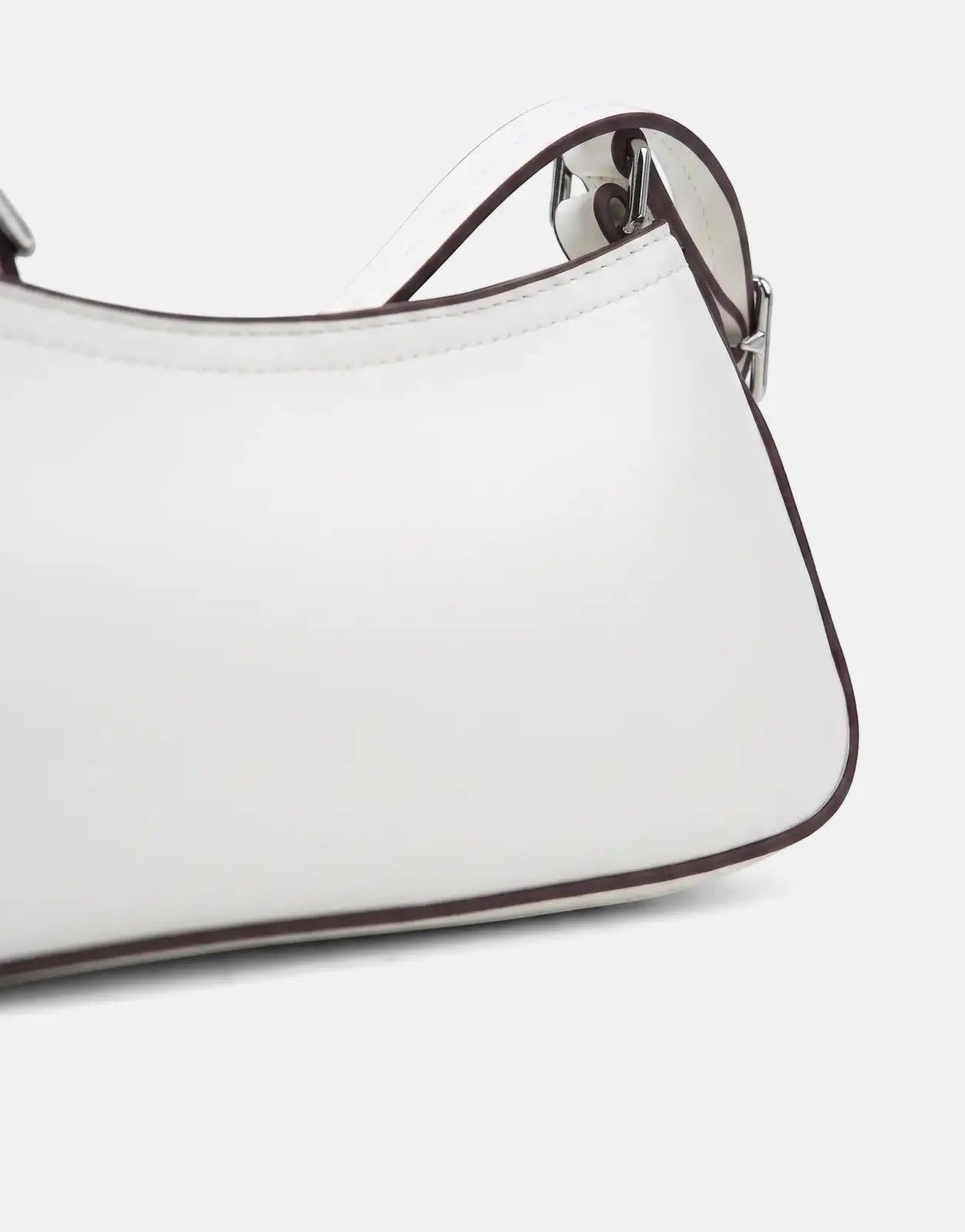 Close-up of a Calvin Klein Small White Shoulder Bag, crafted from white leather-like material with distinct brown piping and