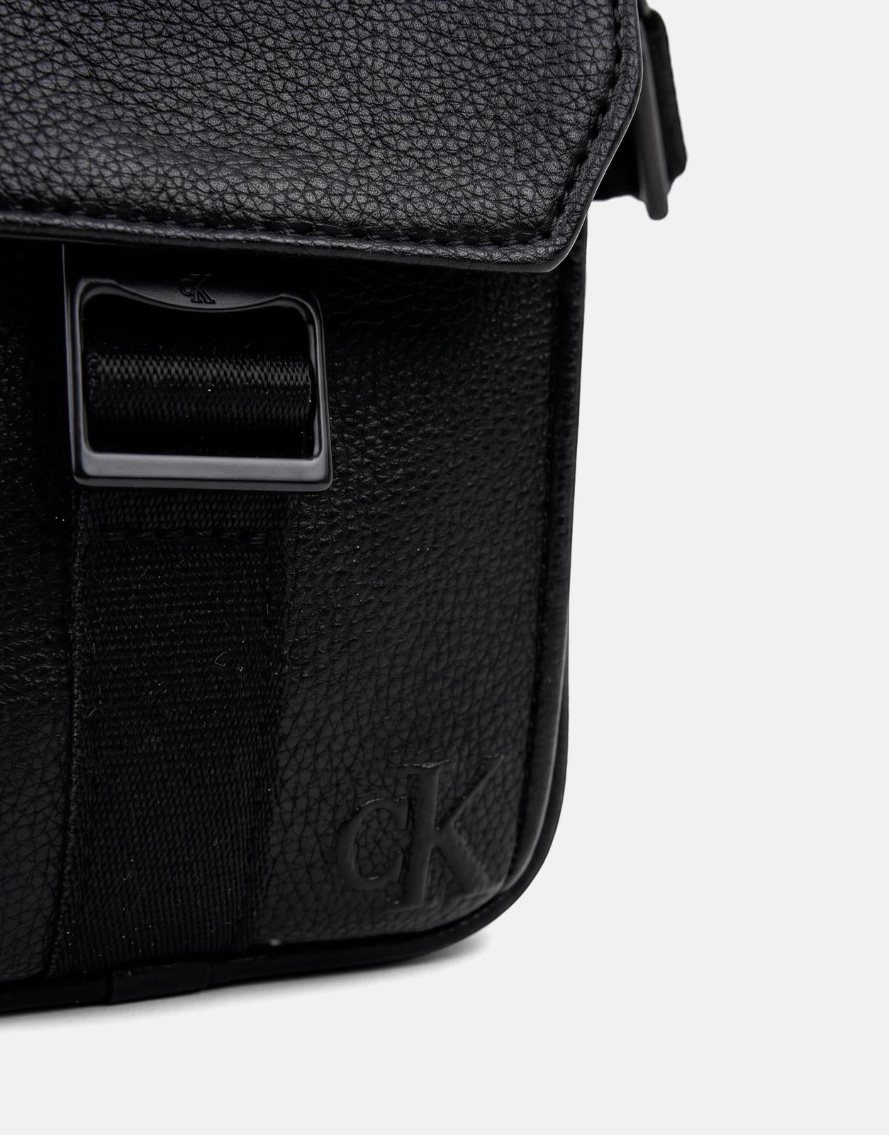 Calvin Klein Webbing Strap Slim Black Reporter Bag, front view, made of textured leather, with an embossed logo.