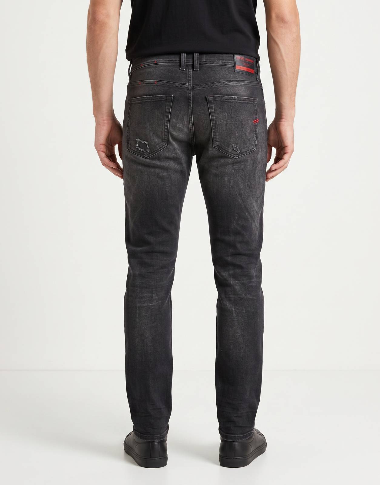 Back view of Diesel 1979 Sleenker Denim Jeans 02 in washed black denim, featuring distressed details and red branding.