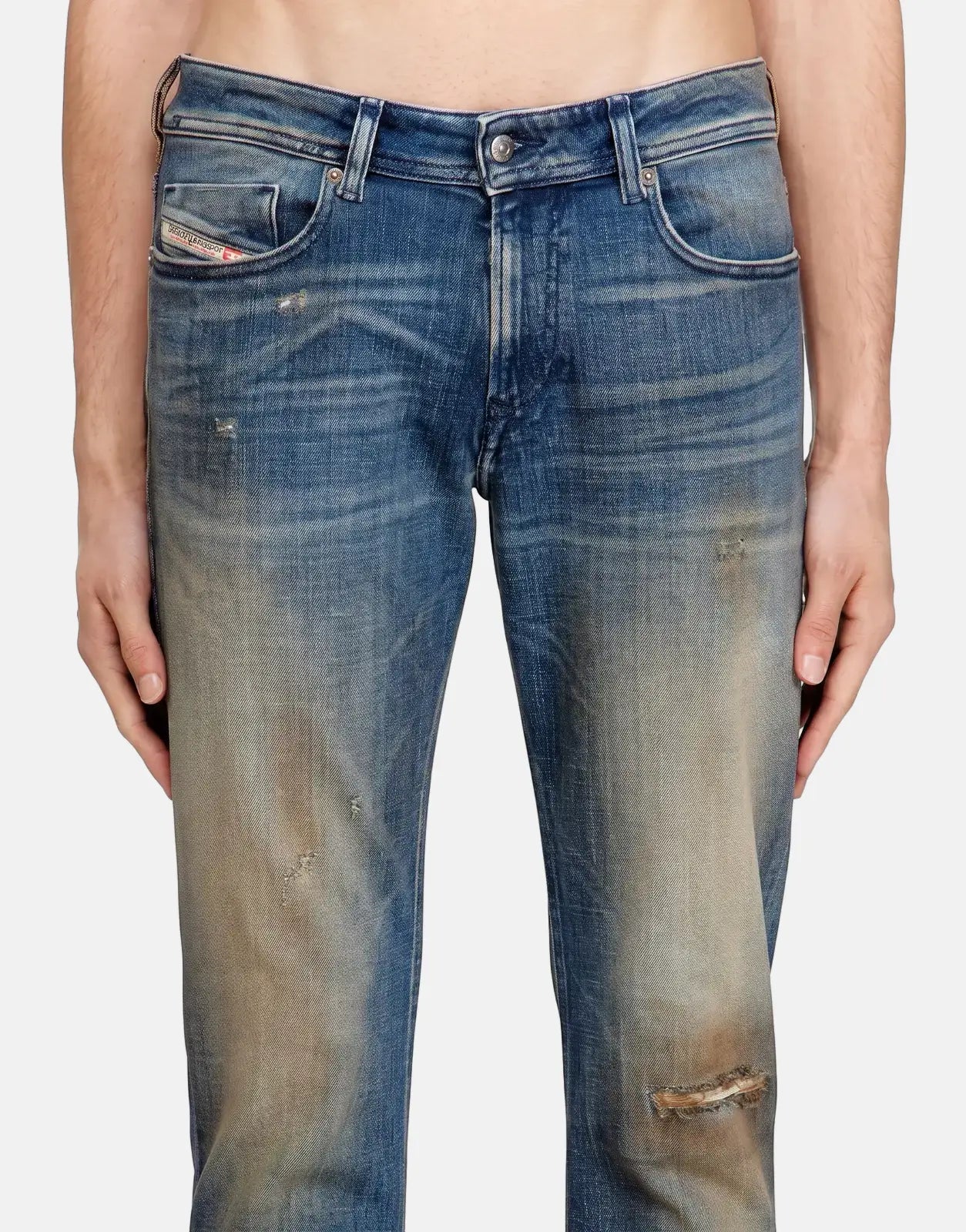 Close-up of men's Diesel 1979 Sleenker skinny denim jeans in blue with distressed details and fading.