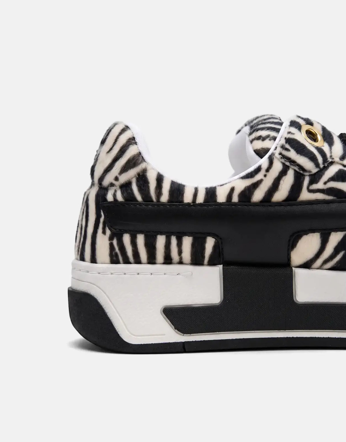 Close-up of a Diesel D-Ollie Low Sneaker featuring black and white zebra print faux fur and black leather details, with a