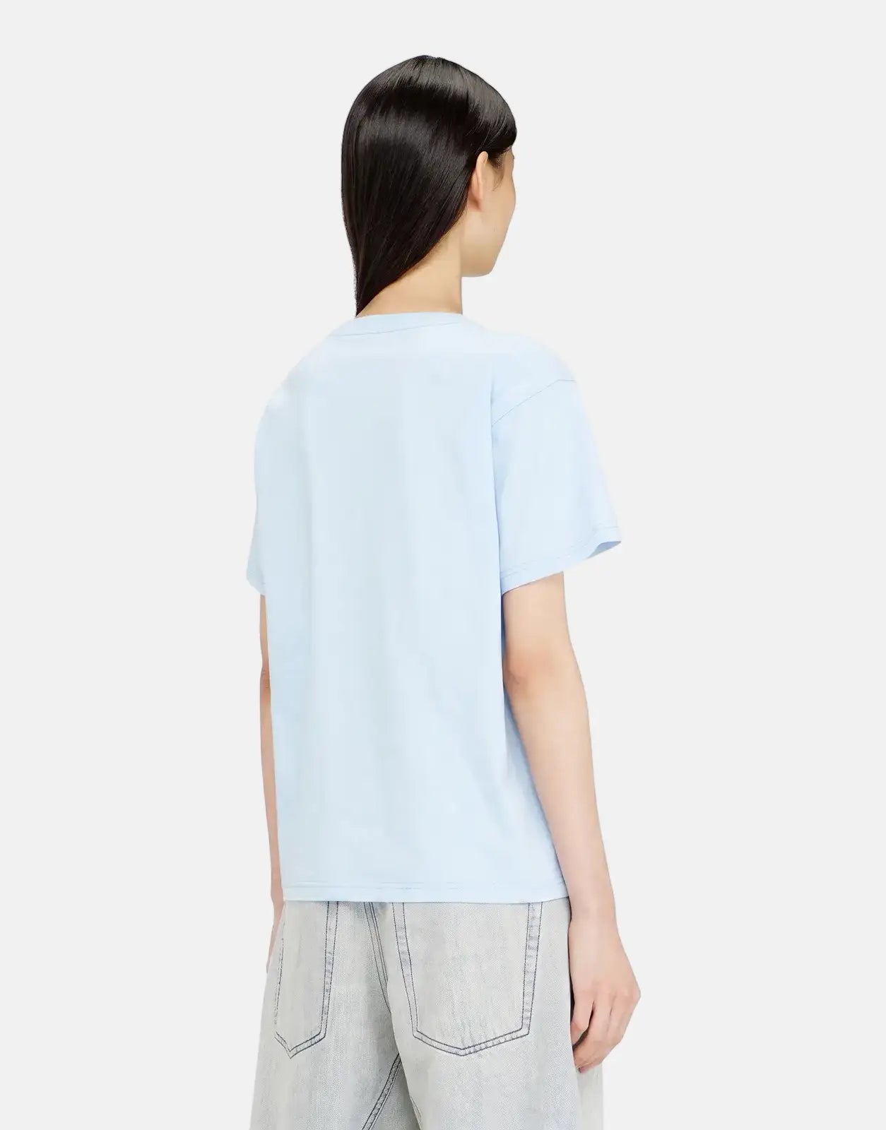 Back view of a female model wearing a Diesel T-Normy S6 Regular T-Shirt 8PE in light blue, paired with light wash denim