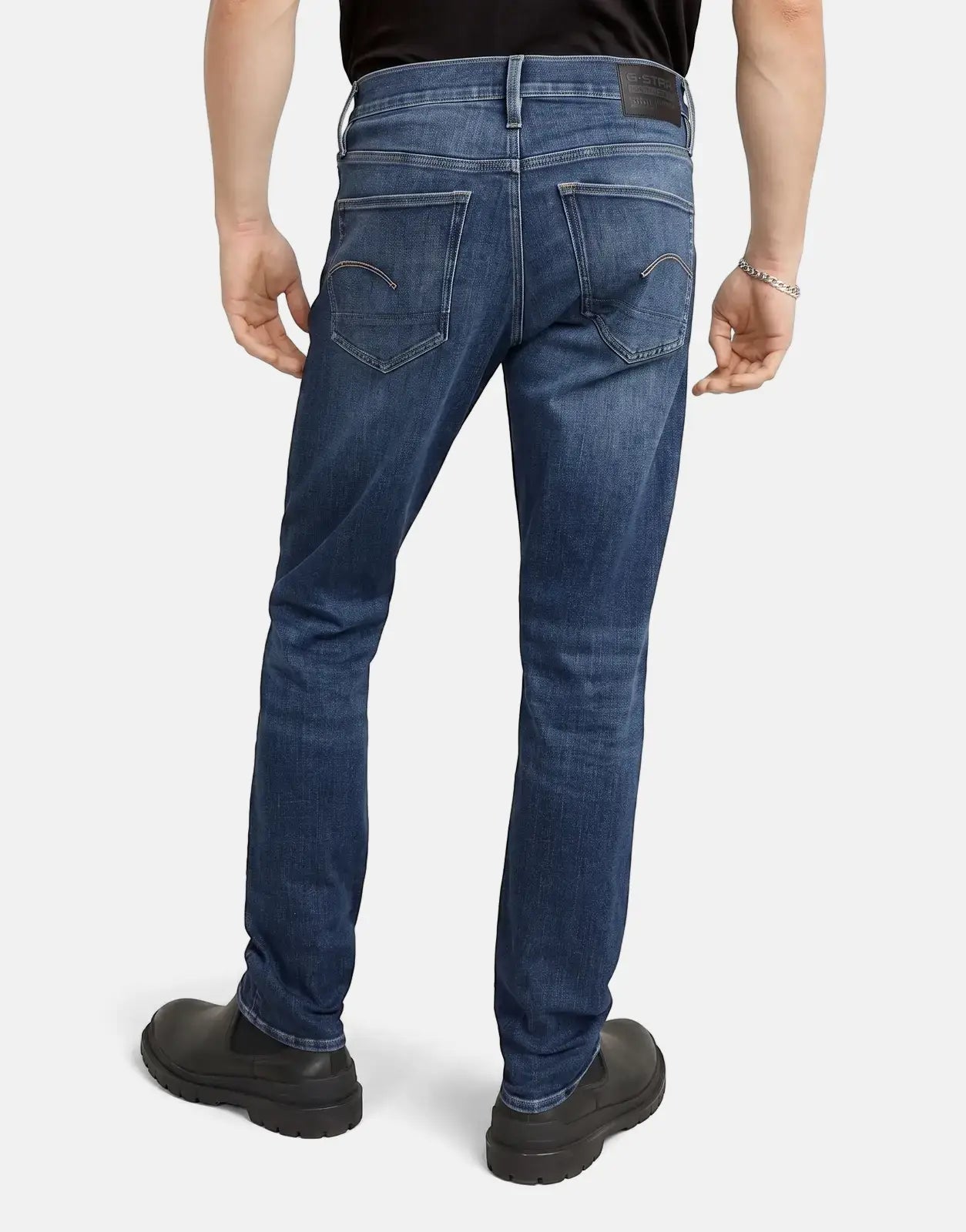 Men's G-Star RAW 3301 Slim Medium Aged Jeans in dark blue denim, shown from the back with black shoes.
