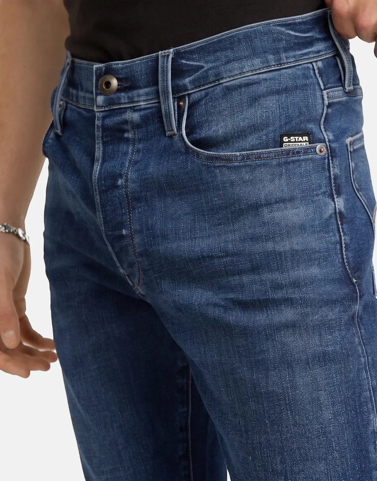 Close-up of G-Star RAW 3301 Slim Medium Aged men's blue jeans, featuring visible branding, classic five-pocket styling, and