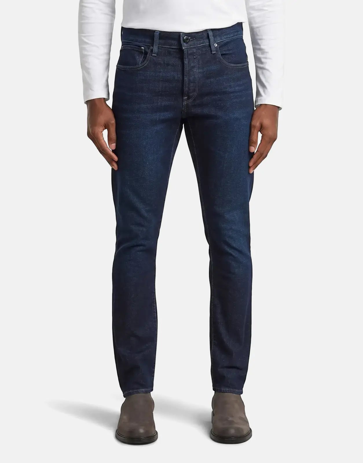 Man wearing G-Star RAW 3301 Worn in Deep Marine slim-fit jeans and brown suede boots, front view.
