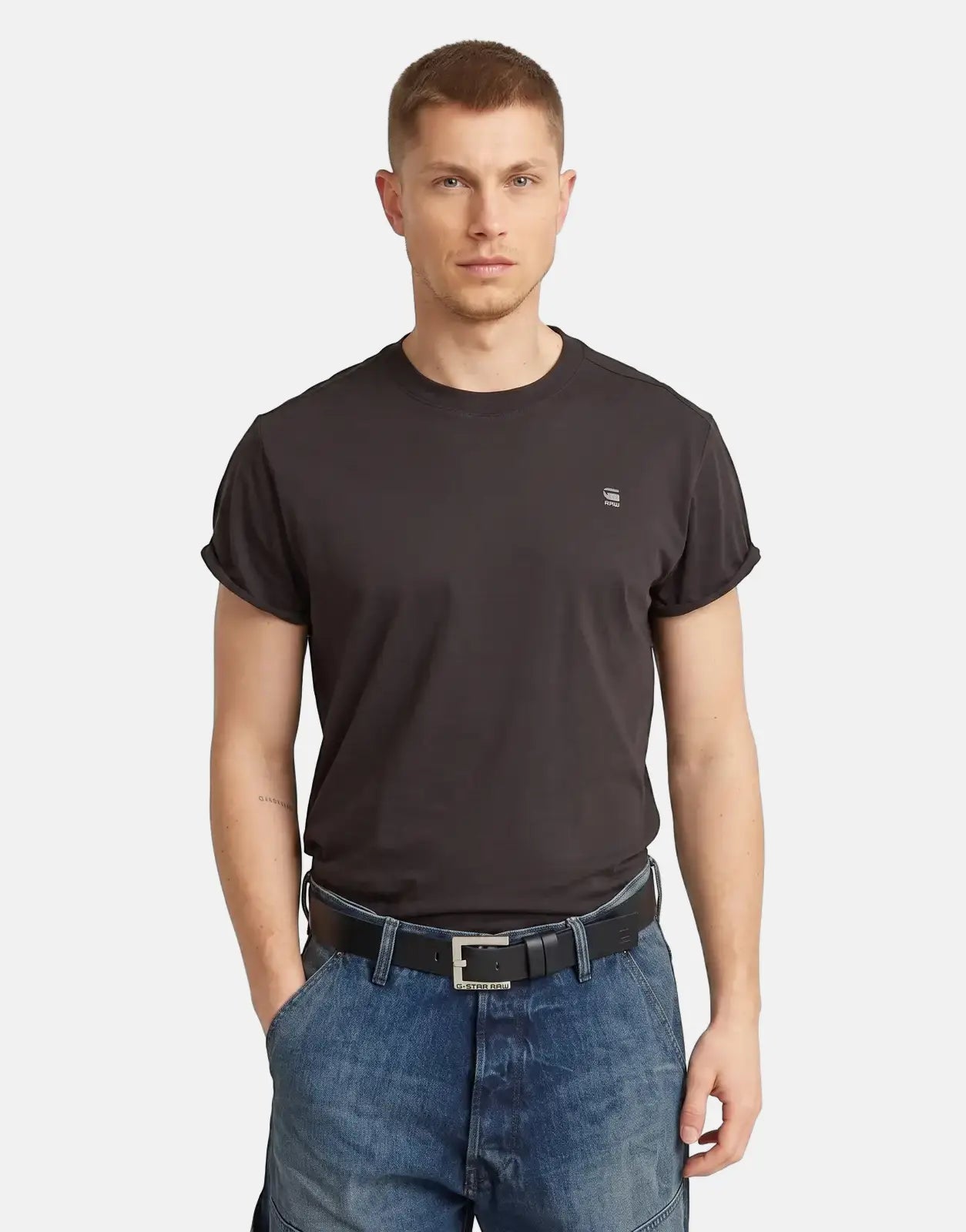 G-Star RAW Duko black leather belt with a rectangular silver buckle, worn by a male model with a black t-shirt and blue