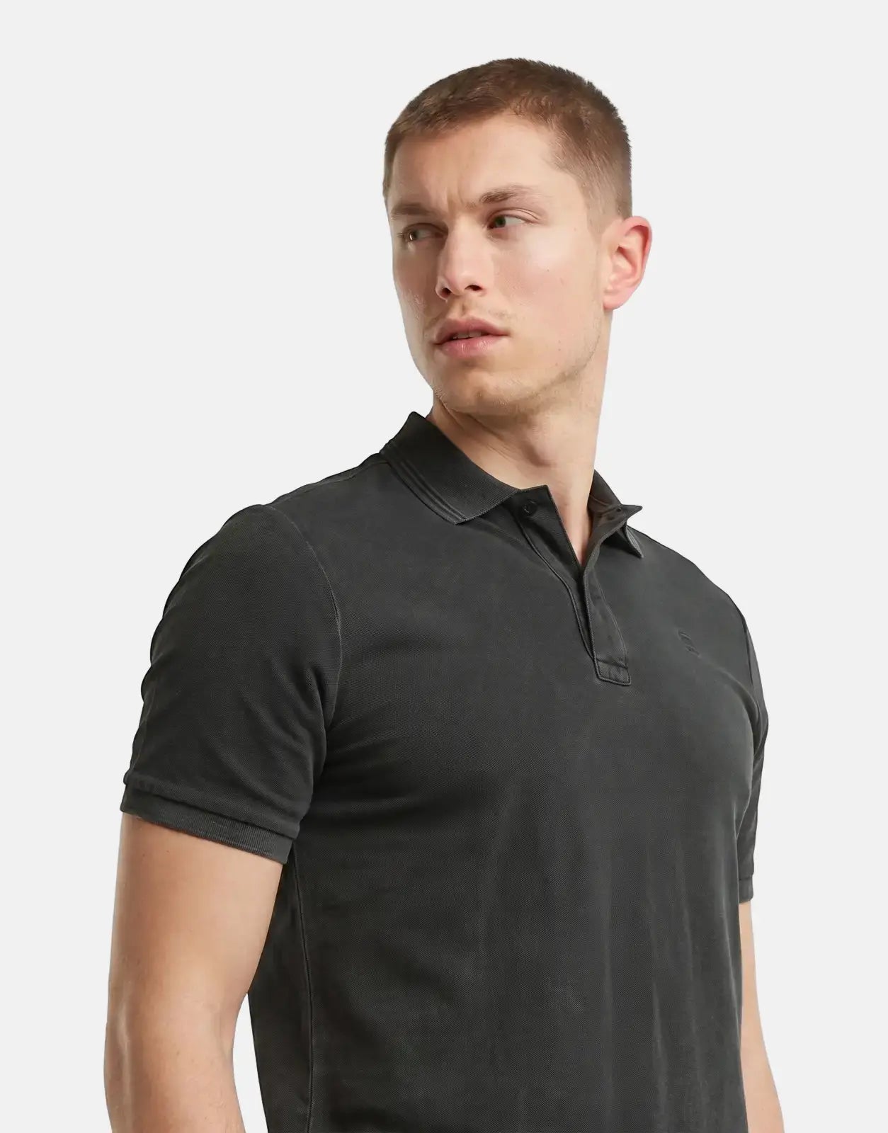 Male model wearing a G-Star RAW Dunda Overdyed Black Slim Polo Shirt in dark gray, shown from the waist up against a neutral