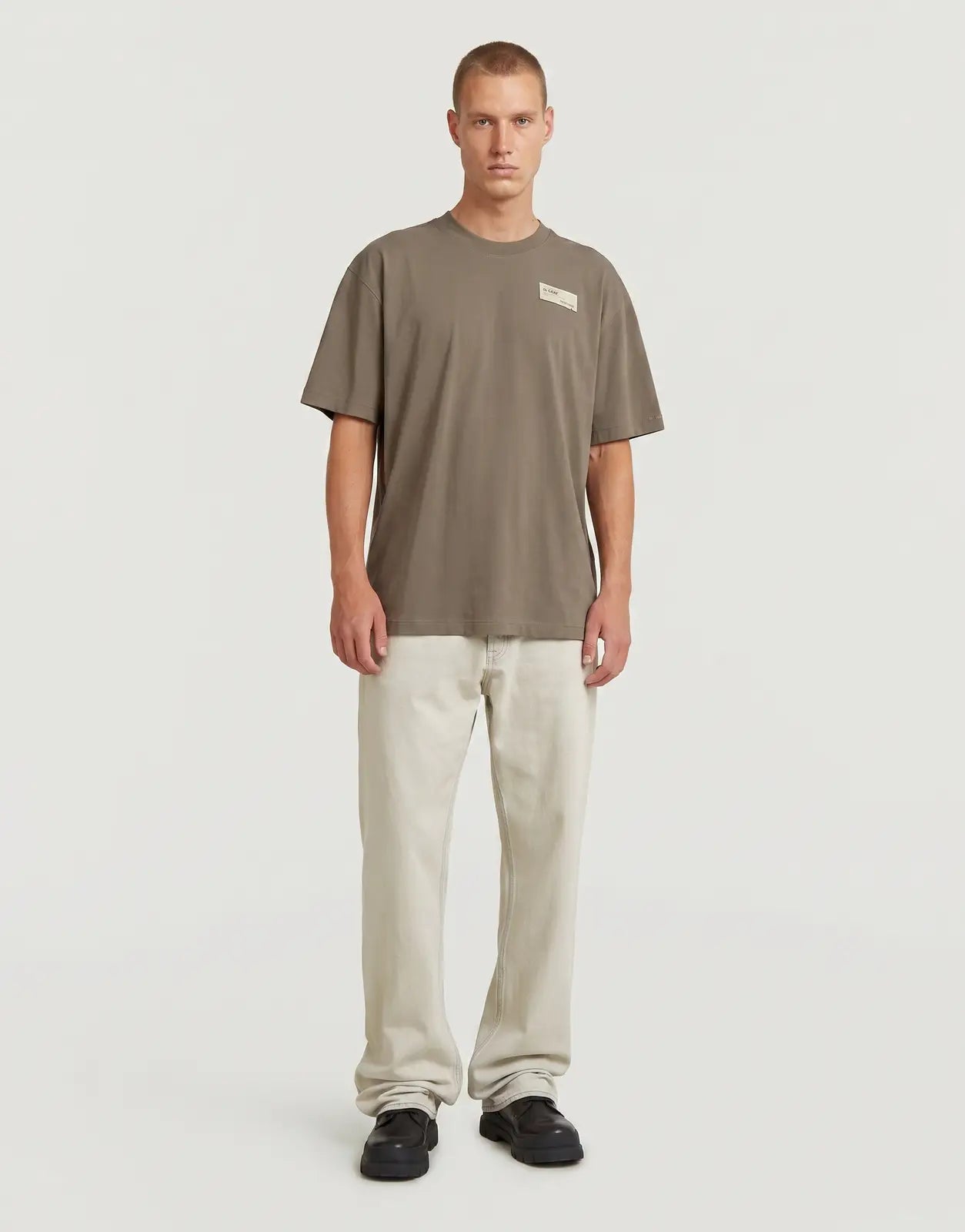Front view of a men's G-Star RAW HB Badge Relaxed Turf t-shirt in a relaxed olive-brown fit, shown on a model.