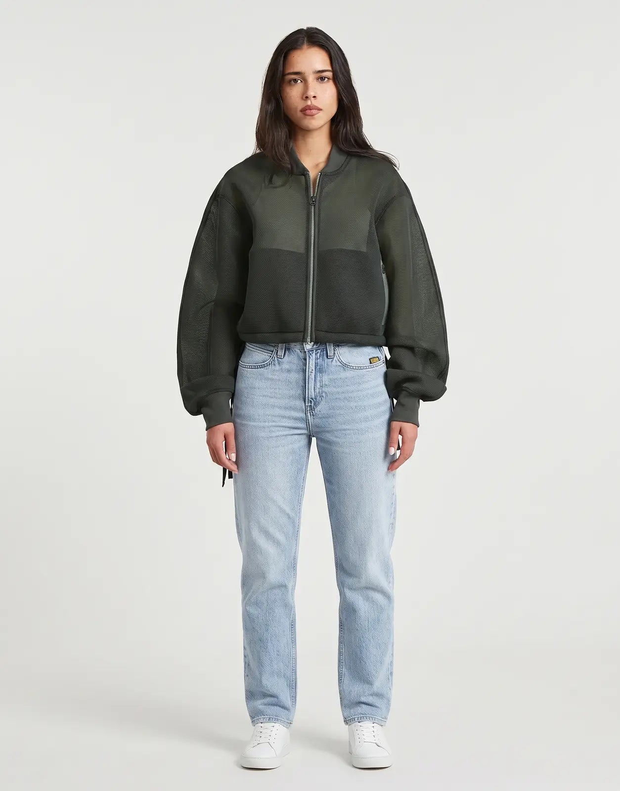 A woman wears a dark green G-Star RAW Meshy Binding Orphus Jacket, highlighting its unique mesh fabric and two-tone design.