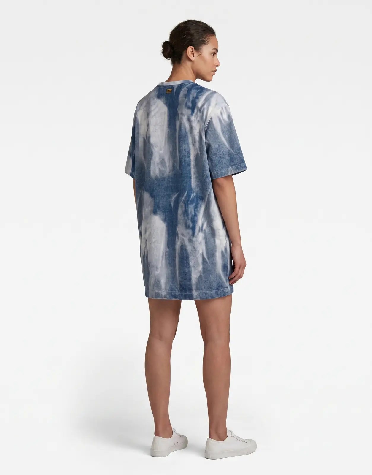 Back view of a model wearing a G-Star RAW Printed Loose Denim Flame Dress in a distinctive blue and white tie-dye pattern.