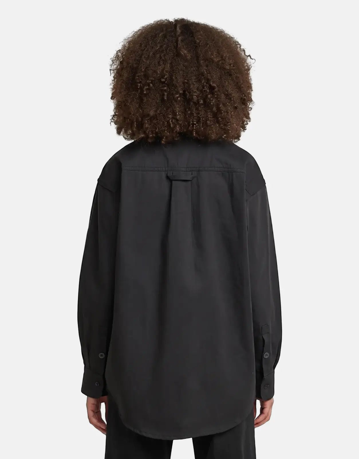 Back view of a person wearing a black G-Star RAW Relaxed Overshirt Raw Denim, showcasing the garment's fit and texture.