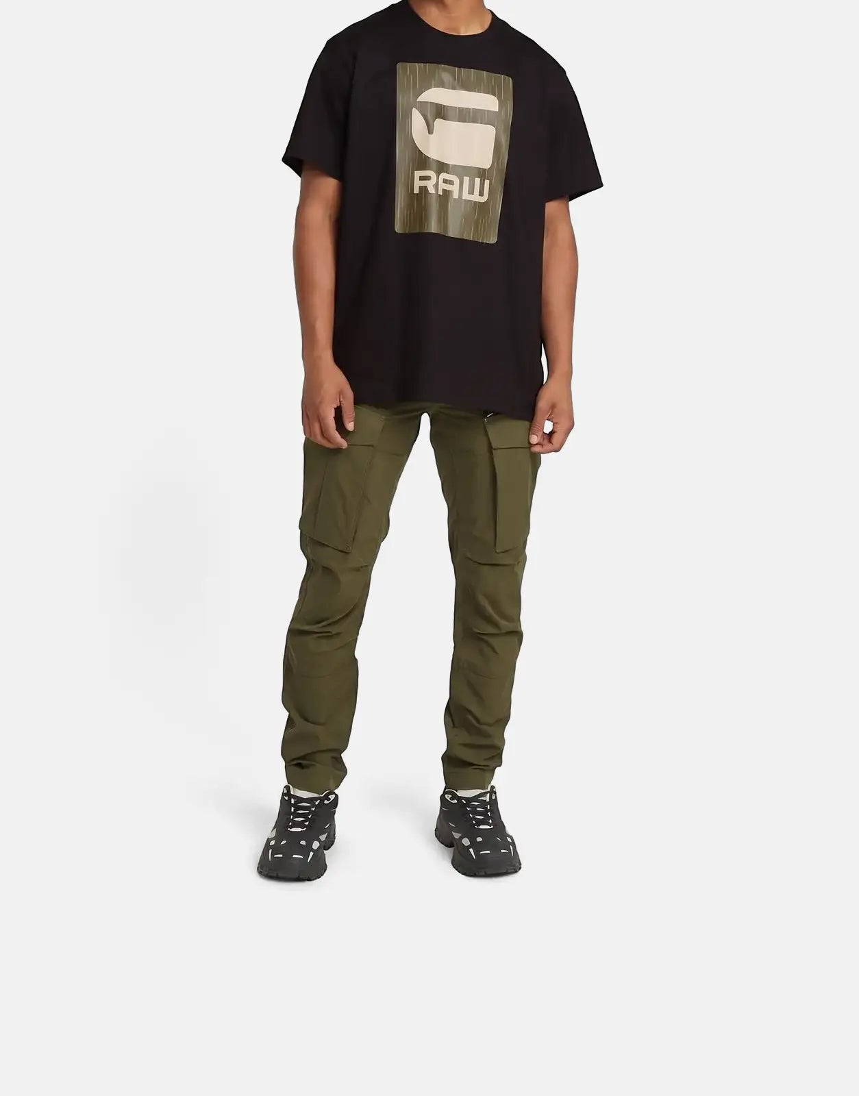 Full body shot of a male model wearing G-Star RAW Rovic Zip 3D Regular Tapered cargo pants in shadow olive, a black logo