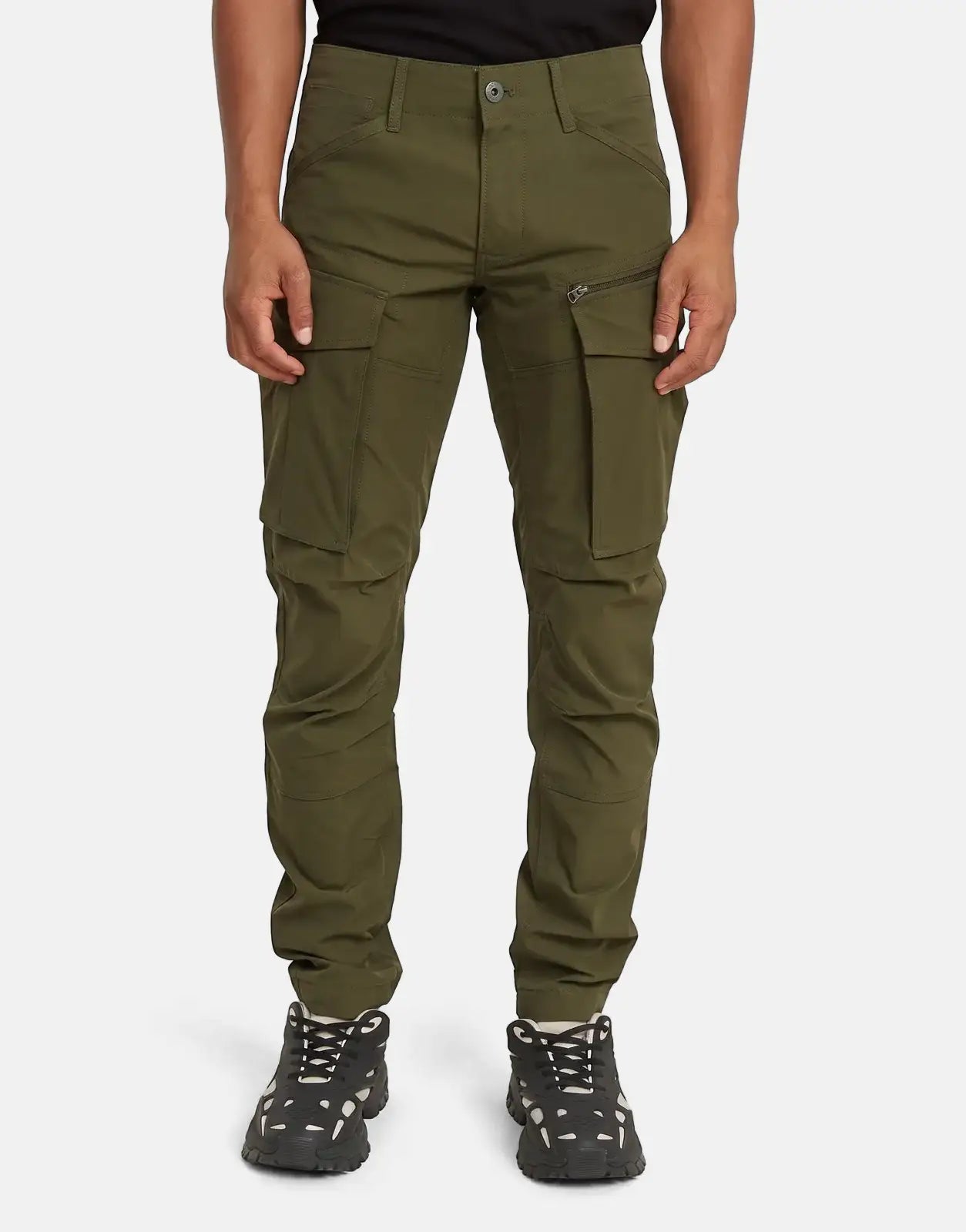 Man wearing G-Star RAW Rovic Zip 3D Regular Tapered Shadow Olive cargo pants and chunky sneakers, frontal view.