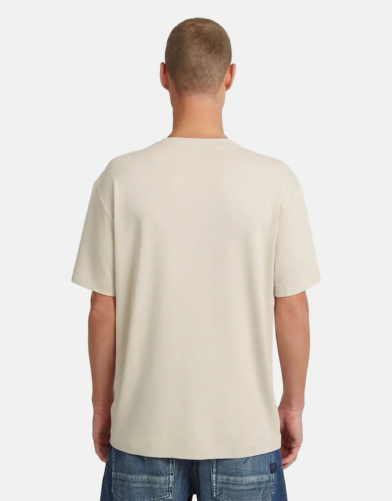 Male model from back wearing a G-Star RAW Script Whitebait T-Shirt in a light beige color and blue jeans.