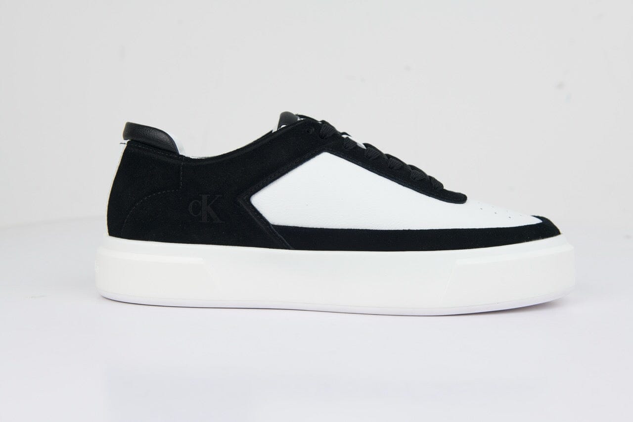 Calvin Klein Basket Cupsole sneaker featuring a white leather upper with black suede accents and a chunky white sole.