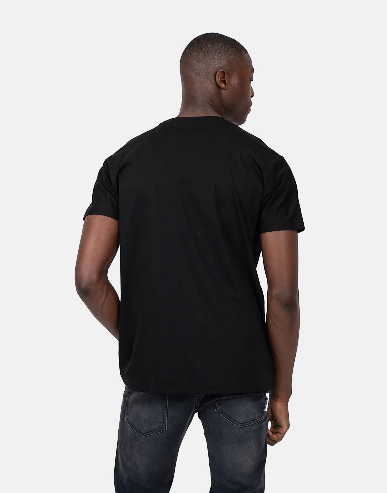 Les Hommes 05 Black T-Shirt on a male model, viewed from the back, paired with dark jeans.