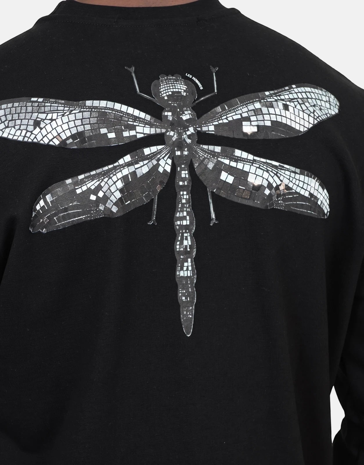 Les Hommes black sweatshirt featuring a detailed silver mosaic-style dragonfly graphic on the back. Close-up view.