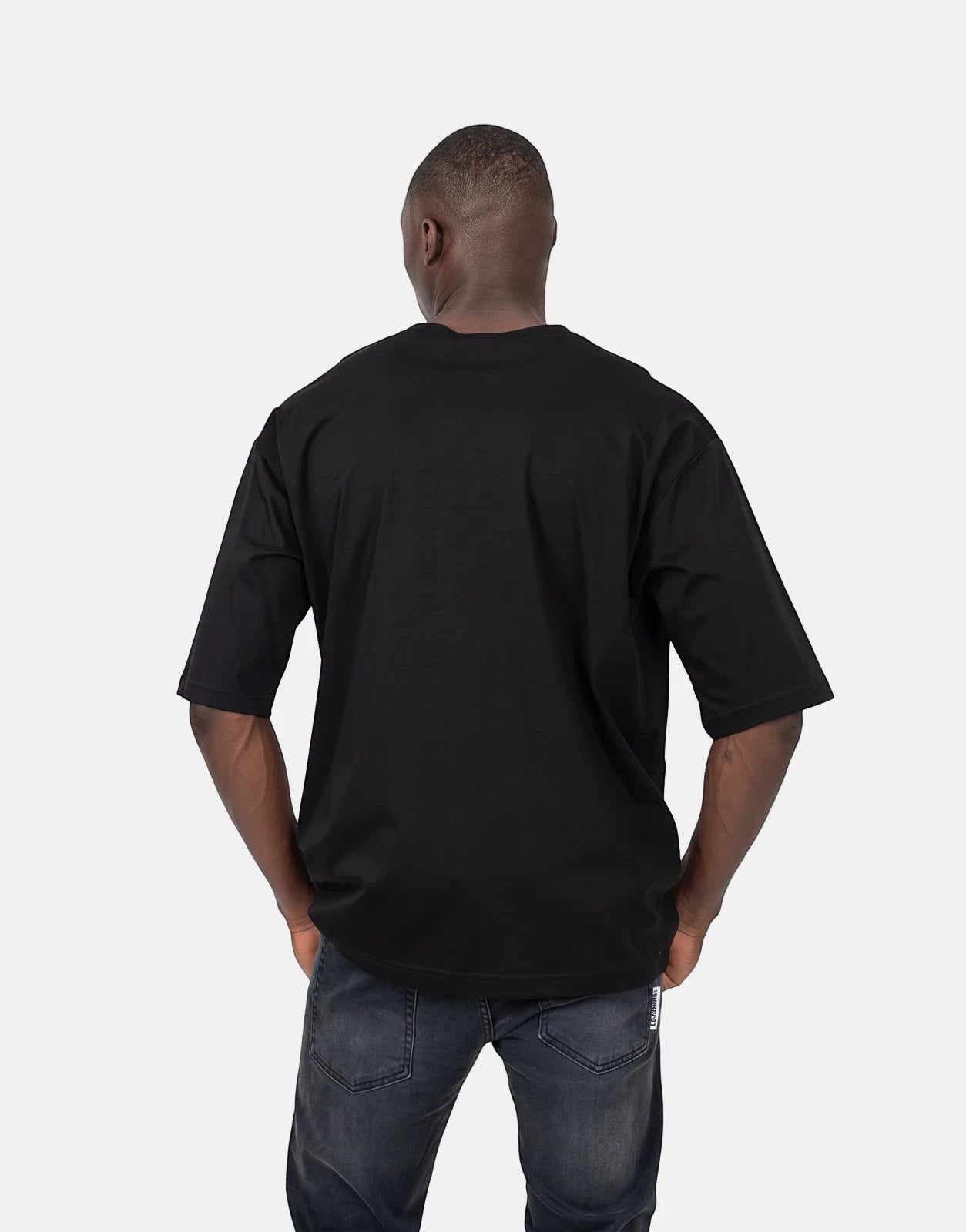 Les Hommes Good Work black t-shirt for men, featuring an oversized fit and short sleeves, shown from the back with dark wash