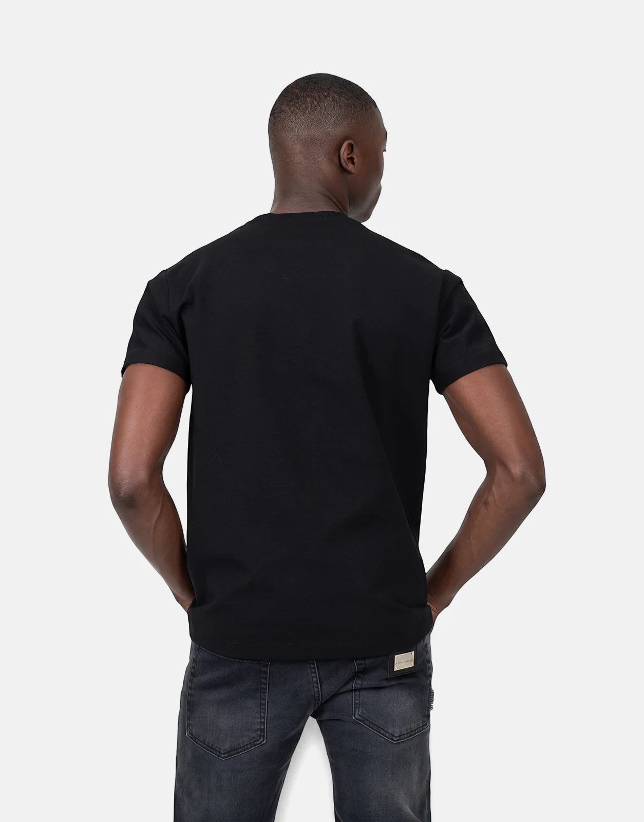 Les Hommes black logo print t-shirt for men, featuring a visible back and short sleeves with dark jeans.