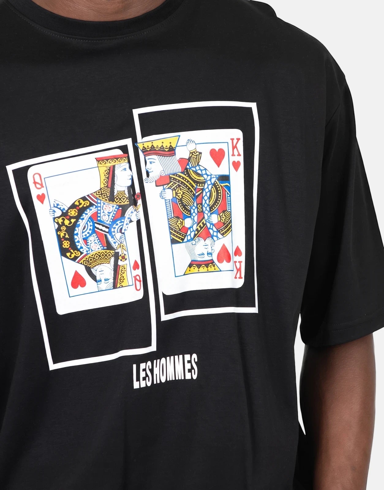 Close-up front view of a Les Hommes black t-shirt featuring a colorful Queen and King of Hearts playing cards graphic.