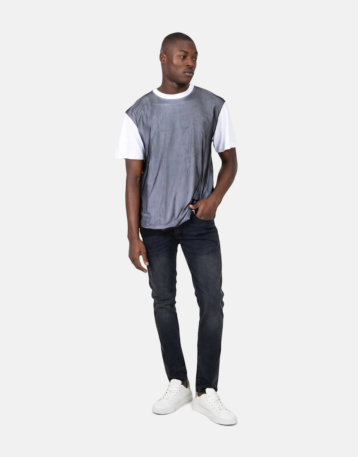 Les Hommes Tulle White T-Shirt layered under a grey mesh top, paired with black jeans and white sneakers on a male model.