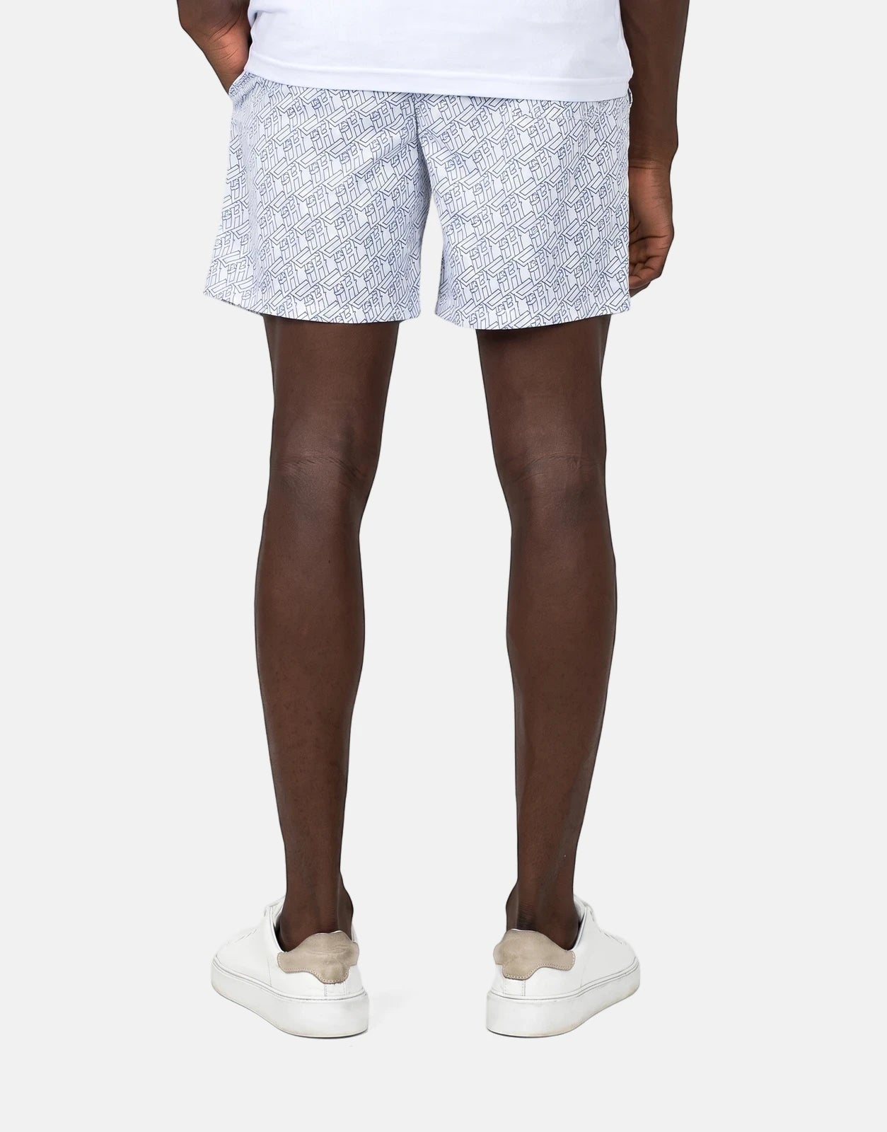 Less Hommes AOP White Swim Shorts for men, featuring a dark geometric all-over print, seen from the back on a model.