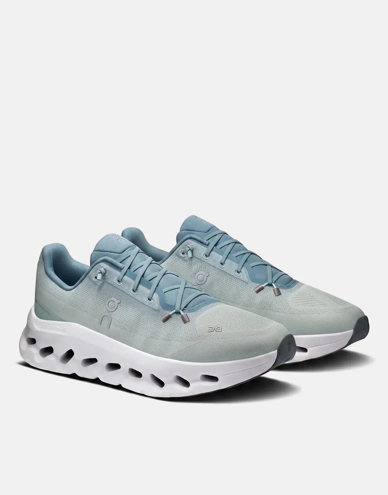 Pair of On Men's Cloudtilt Tide Mineral running sneakers in light blue with white cushioned soles, viewed from an angled