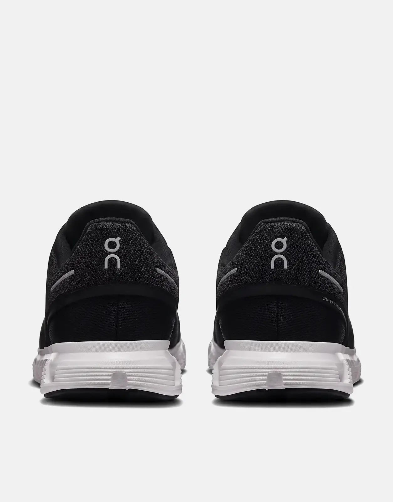 Black and white On Men's Cloud 6 sneakers, shown from the rear view, highlighting the heel and sole design.