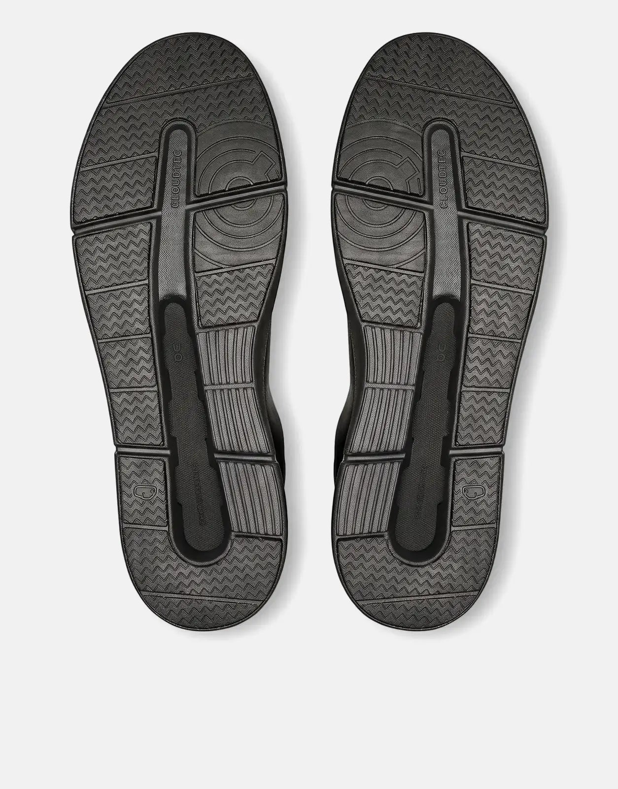 Pair of On Men's Roger Advantage black sneakers, viewed from below showing the textured soles.