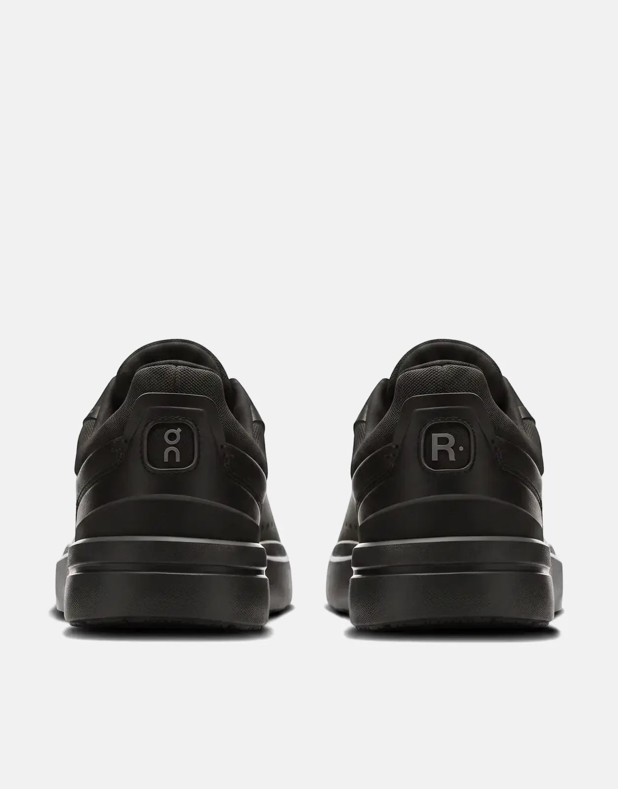 On Men's Roger Advantage black sneakers, featuring the 'o𝕔' and 'R.' logos on the heel, displayed from the back.