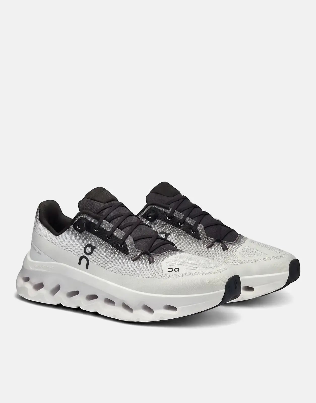 Pair of On Unisex Cloudtilt Black Ivory Sneakers on a white background, showing the side profile and textured sole.