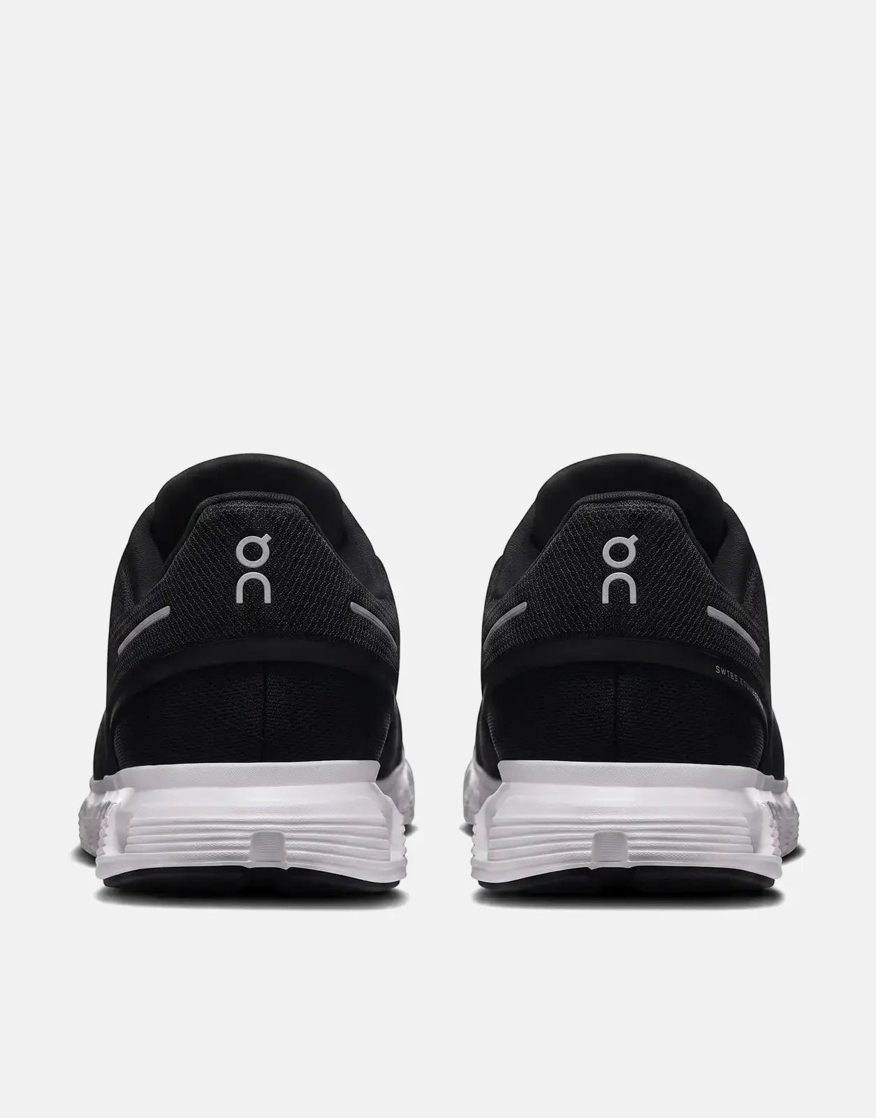 On Women's Cloud 6 sneakers in black and white, featuring a mesh upper and cloud-like sole, shown from the rear view.