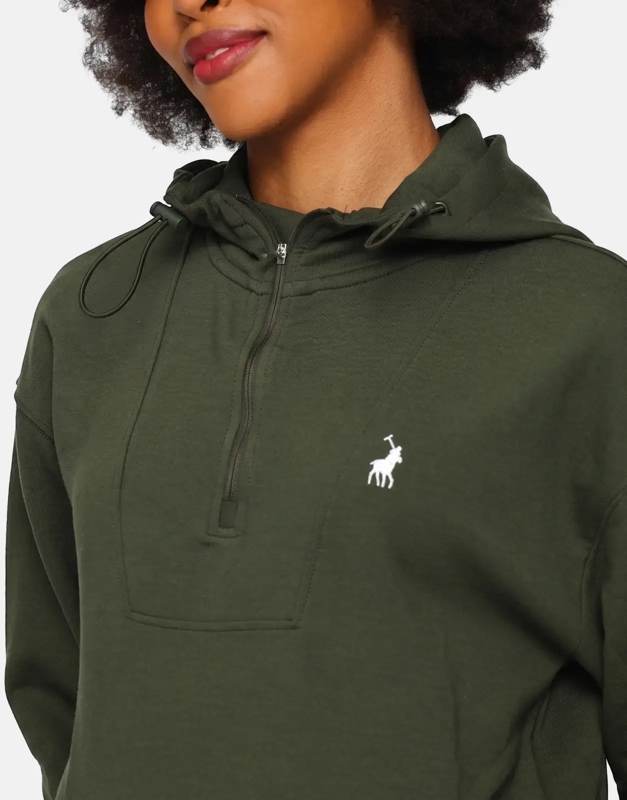 Close-up of a woman wearing a dark green Polo Robyn long sleeve quarter-zip track top with a white logo.